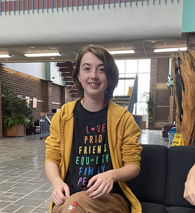 IMAGE #28 – head shot, student in atrium wearing yellow hoodie copy